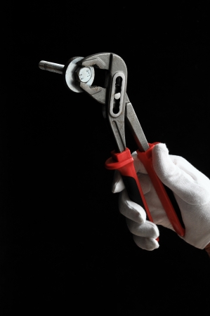 Pliers and a Hand on a Black Backgroundの写真素材