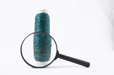 Roll of Twine and Loupe on a White Background