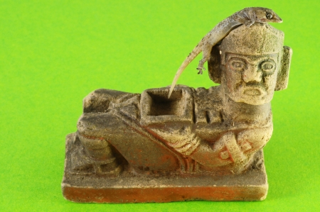 One Small Gecko Lizard and Mayan Statue on a Colored Backgroundの写真素材