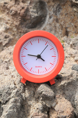 One Red Clock on the Rocks Near the Ocean 
