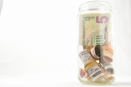 Savings Concept Money in a Glass Jar on a White Background
