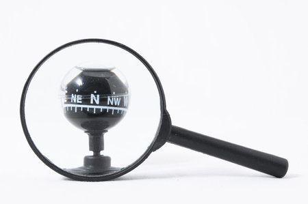 Orientation Concept Magnify Glass and Compass on a White 