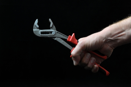 Pliers and a Hand on a Black Backgroundの写真素材