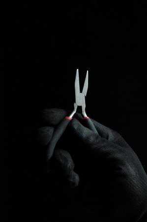 Pliers and a Hand on Black Backgroundの写真素材