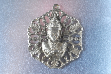 Silver Buddha Pendant Jewel over a Colored Backgroundの写真素材