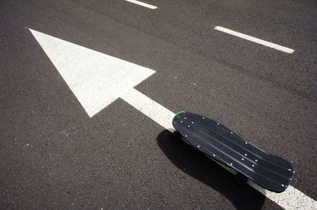 Vintage Style Longboard Black Skateboard on an Empty Asphalt Desert Road