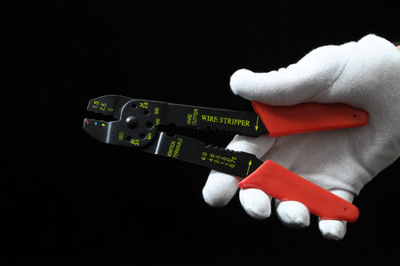 Pliers and a Hand on Black Backgroundの写真素材