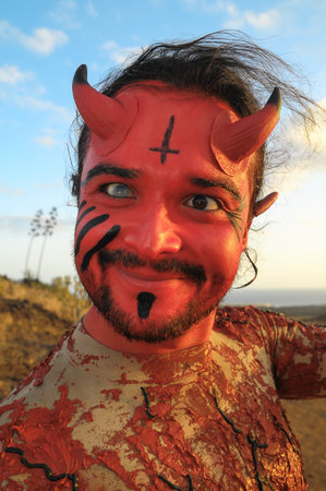 Latin American Man with Long Hairs Masked as a Devil in the Desert