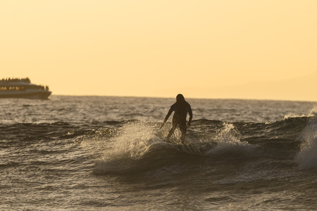 Backlight Silhouette Surfer in the Ocean at Sunsetの写真素材