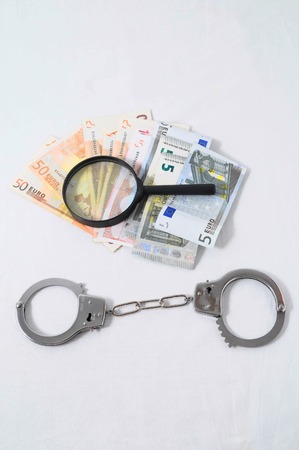 Financial Concept Loupe and Money on a White Backgroundの写真素材