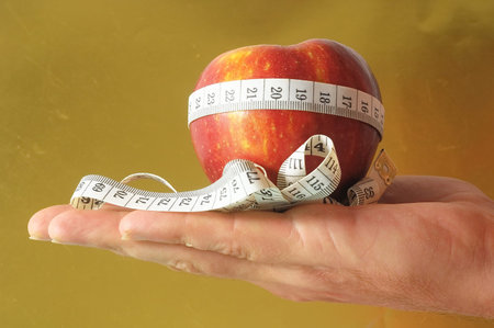 Diet Apple and Meter on the Hand a Colored Background