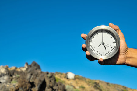 Time Concept White Sand Hourglass on the Volcanic Rocks
