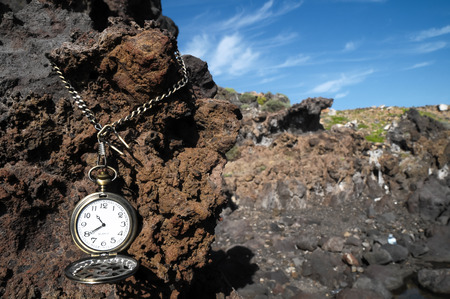 Time Concept Classic Vintage Pocket Clock on the Volcanic Rocksの写真素材