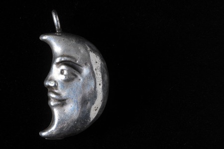 Half Moon Silver Jewel over a Colored Backgroundの写真素材