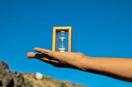 Time Concept White Sand Hourglass on the Volcanic Rocksの写真素材