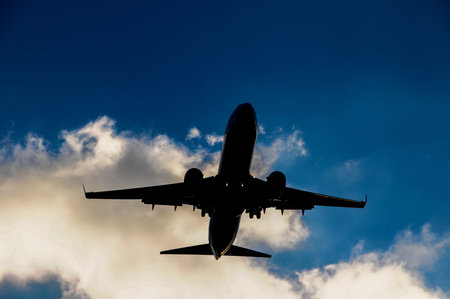 Silhouette of an Airplane Landing into a evening sky