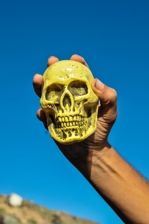 Vintage Old Skull and Human Hand over a Blue Skyの写真素材