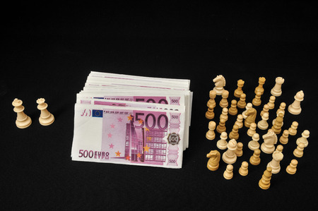 Money Strategy Concept White Chess and Currency on a Black Backgroundの写真素材