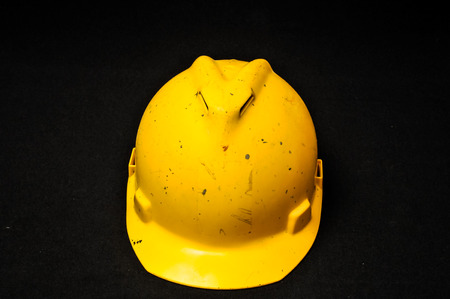 Yellow Safety Helmet on a Black Backgroundの写真素材