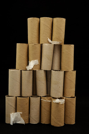 Empty Toilet Rolls Stack Up On a Black Backgroundの写真素材