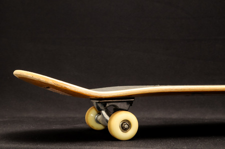 Vintage Style Black Skateboard on a Dark Backgroundの写真素材