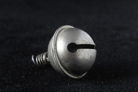 Vintage Small Metal Bell on a Black Backgroundの写真素材