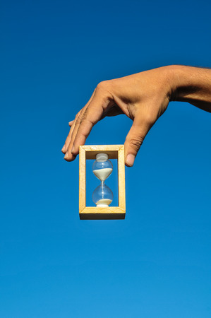 Time Concept White Sand Hourglass on the Volcanic Rocksの写真素材