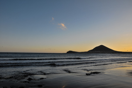 Sunset on the Atlantic Ocean with a Mountain in Background El Medano Tenerife Canary Islands Spainの写真素材
