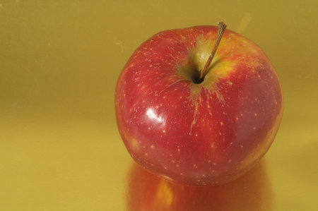 One Juicy Hot Red Apple over a Colored Background