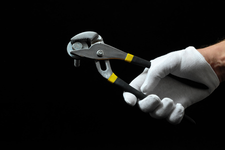 Pliers and a Hand on a Black Backgroundの写真素材