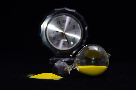 Deadline Concept Broken Hourglass with Yellow Sand on Black Backgroundの写真素材