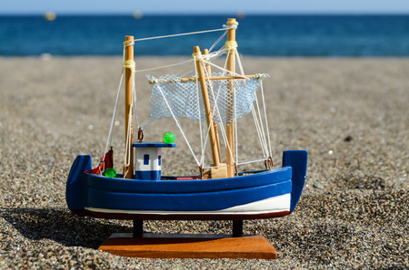 Sail Ship Toy Model in the Beach Sand Close-upの写真素材