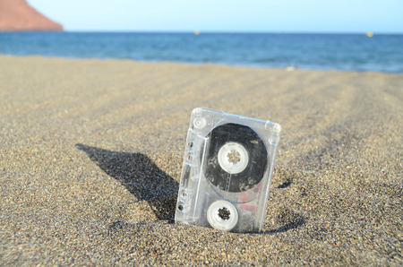 Ancient Retro Musicassette on the Sand near the Waterの写真素材