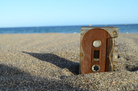 Ancient Retro Musicassette on the Sand near the Waterの写真素材
