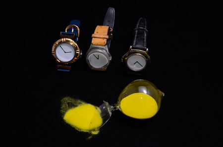 Deadline Concept Broken Hourglass with Yellow Sand on Black Backgroundの写真素材