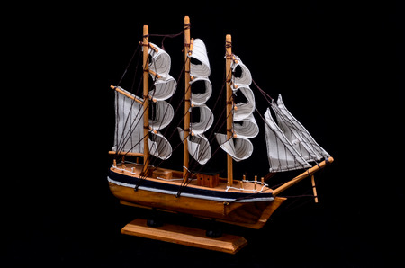 Ship Sailboat Wooden Model Figurine on a Black Backgroundの写真素材