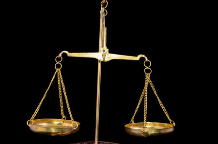 Golden Two Pan Balance Weight on a Black Bacground