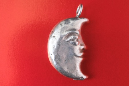 Half Moon Silver Jewel over a Colored Backgroundの写真素材