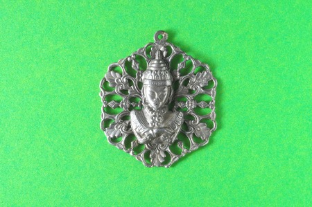Silver Buddha Pendant Jewel over a Colored Backgroundの写真素材
