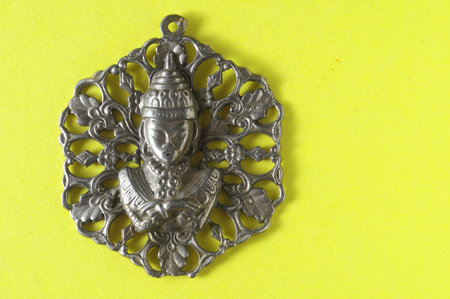 Silver Buddha Pendant Jewel over a Colored Backgroundの写真素材