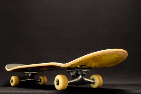 Vintage Style Black Skateboard on a black Backgroundの写真素材