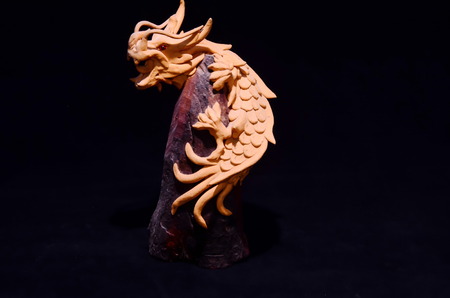 Wood Handmade Statue of a Dragon on Black Backgroundの写真素材