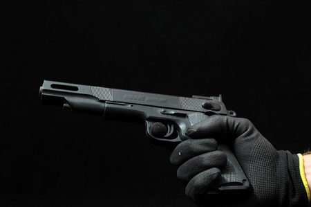 Gun and a Hand on a Black Backgroundの写真素材