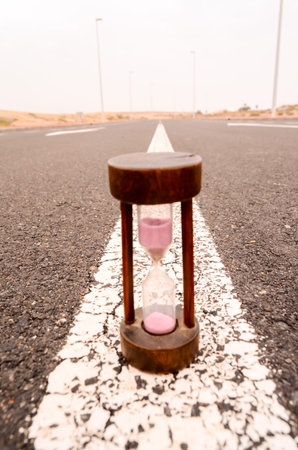Time Concept Alarm Hourglass on the Asphalt Street