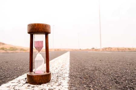 Time Concept Alarm Hourglass on the Asphalt Street
