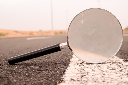 Travel Concept Magnify Glass Loupe on the Asphlat Roadの写真素材