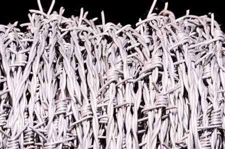 Roll of Barbed Wire over a Black Backgroundの写真素材