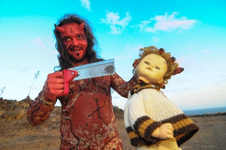 Latin American Man with Long Hairs Masked as a Devil in the Desertの写真素材