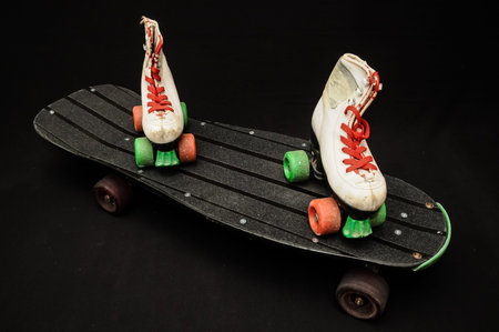 Vintage Style Black Skateboard and Skate Boot on a Dark Backgroundの写真素材