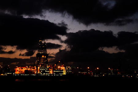 Oil Drilling Rig Silhouette over a Cloudy Skyの写真素材